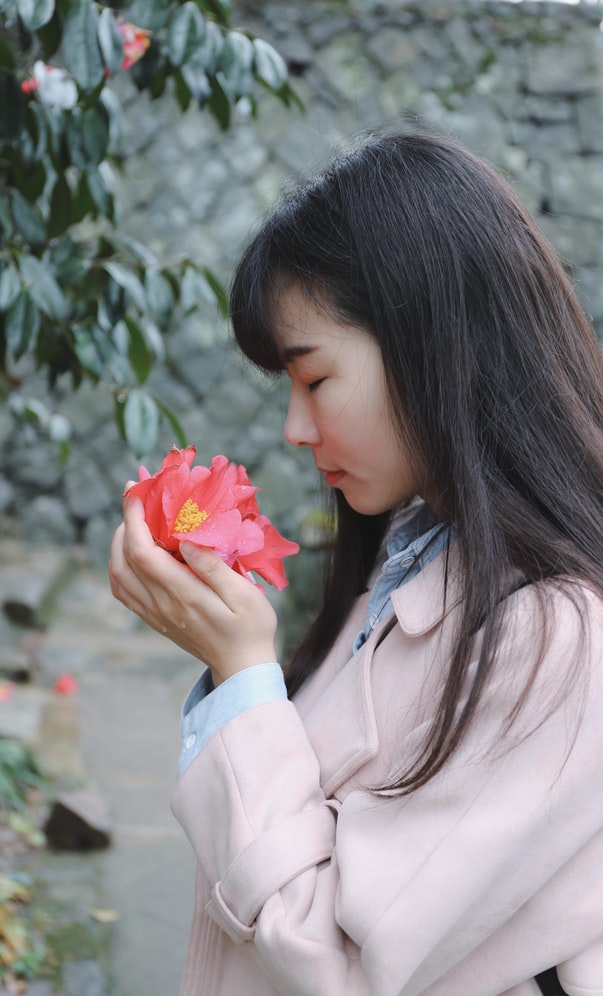 Chica oliendo una flor en actitud de Atención Plena