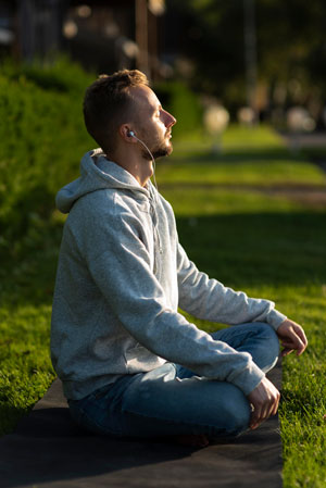 Meditación. Mindfulness y depresión. Chico joven meditando en un parque.
