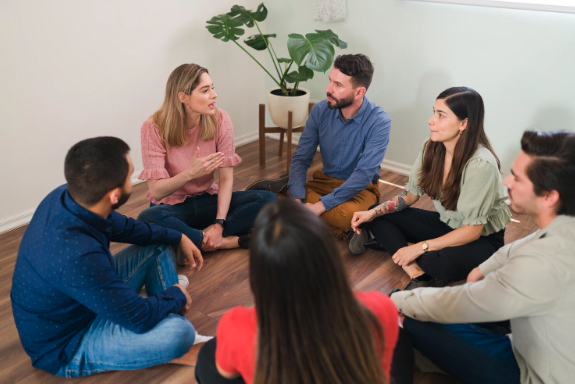 Mindfulness para las empresas. Personas sentadas en el suelo, hablando.